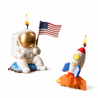 Southlake Gifts Astronaut and Rocket Candle are both lit in the white background. A playful space-themed birthday cake topper featuring for space themed birthday decoration.