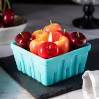 Southlake Gifts Cherry Basket Candle glowing with colorful cherry wax melts in a blue wax basket, a playful fruit candle for kitchen décor and foodie gifts.