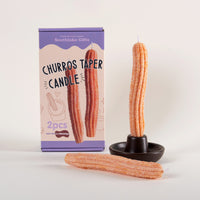 Southlake Gifts Churros Taper Candle Set with two handmade churro-shaped candles beside a gift box and holder on a clean white background. A realistic dessert-inspired candle that makes a charming holiday or housewarming gift for candle lovers and design enthusiasts.