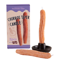 Southlake Gifts Churros Taper Candle Set with two handmade churro-shaped candles beside a gift box and holder on a clean white background. A realistic dessert-inspired candle that makes a charming holiday or housewarming gift for candle lovers and design enthusiasts.