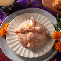 Handmade Pan de Muerto Candle by Southlake Gifts, bread-shaped vanilla scented food candle with sugar wax sprinkles for Day of the Dead décor.