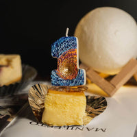 Southlake Gifts Galaxy black hole number 1 candle standing on cheesecake dessert with moon lamp backdrop, unique space themed birthday candle and cake decoration.