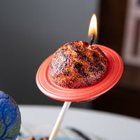 Southlake Gifts Saturn planet cake topper candle close up with lit wick, handmade unscented space themed candle for galaxy party décor, unique birthday cake decoration and gift for space lovers