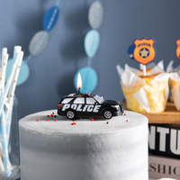 Southlake Gifts police car candle displayed on cake with party decorations, police themed party favor idea, cop birthday setup with patrol car candle, novelty candle gift for kids, police officer appreciation and support blue theme