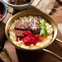 Southlake Gifts Ramen Noodle Candle, handmade novelty food candle in golden ramen pot with wax beef slices, scallions, mushrooms, and chili peppers.