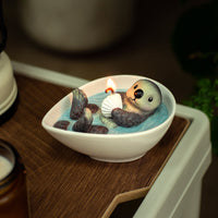 Handcrafted Sea Otter Candle from Southlake Gifts with sea salt scented wax, lifelike otter floating peacefully in a ceramic bowl, a charming handmade candle ideal for holiday gifting.