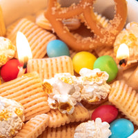 Macro detail of Southlake Gifts realistic snack-shaped wax elements including popcorn and crackers inside the Snacks Candle Bowl, emphasizing handcrafted artistry, an artisan handmade candle perfect as a playful yet elevated gift.