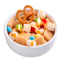 Scented Snacks Bowl Candle is lit up in a white background It is filled with pretzel and popcorn-shaped wax melts, handcrafted by Southlake Gifts — an artisan handmade candle perfect for home décor gifting.