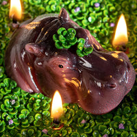 Southlake Gifts Hippo Candle is lit and has a close-up look, a hand-painted soy wax animal candle in a bowl with moss pond design, floral fragrance décor
