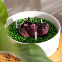 Southlake Gift Hippo-shaped candle on a bed of green grass in a white bowl.