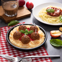 Southlake Gifts realistic Spaghetti and Meatballs Candle featuring wax basil leaves and tomato sauce, displayed beside a real pasta dish to highlight its lifelike handmade details — an artisan food candle that makes a perfect food candle gift for home décor and candle lovers.