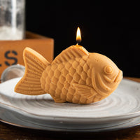 Southlake Gifts taiyaki candle styled on plate with lit wick, realistic Japanese dessert candle inspired by street food, handmade scented soy wax novelty candle, unique gift for food lovers and kawaii home decor