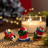the back of the Santa and reindeer wax figures inside holiday candle, handmade Christmas décor with sleigh of gifts, floral fruit gourmand fragrance