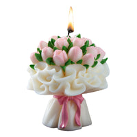 Southlake Gifts Pink Tulip Floral Bouquet Candle with pink ribbon is lit up on a white background.