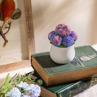 Hydrangea Candle styled on a wooden stand with soft natural lighting, showing elegant pastel color petals — a handmade floral candle that makes a perfect holiday gift for candle collectors and décor fans.