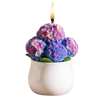 Southlake Gifts Purple Hydrangea flower candle is lit up in a white background.