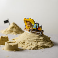 Southlake Gifts Excavator Candle styled in a miniature construction scene with sand and props, a handcrafted soy candle that works as a fun cake topper and novelty décor gift.
