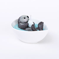 The back view of the cute sea otter animal candle in the white background.