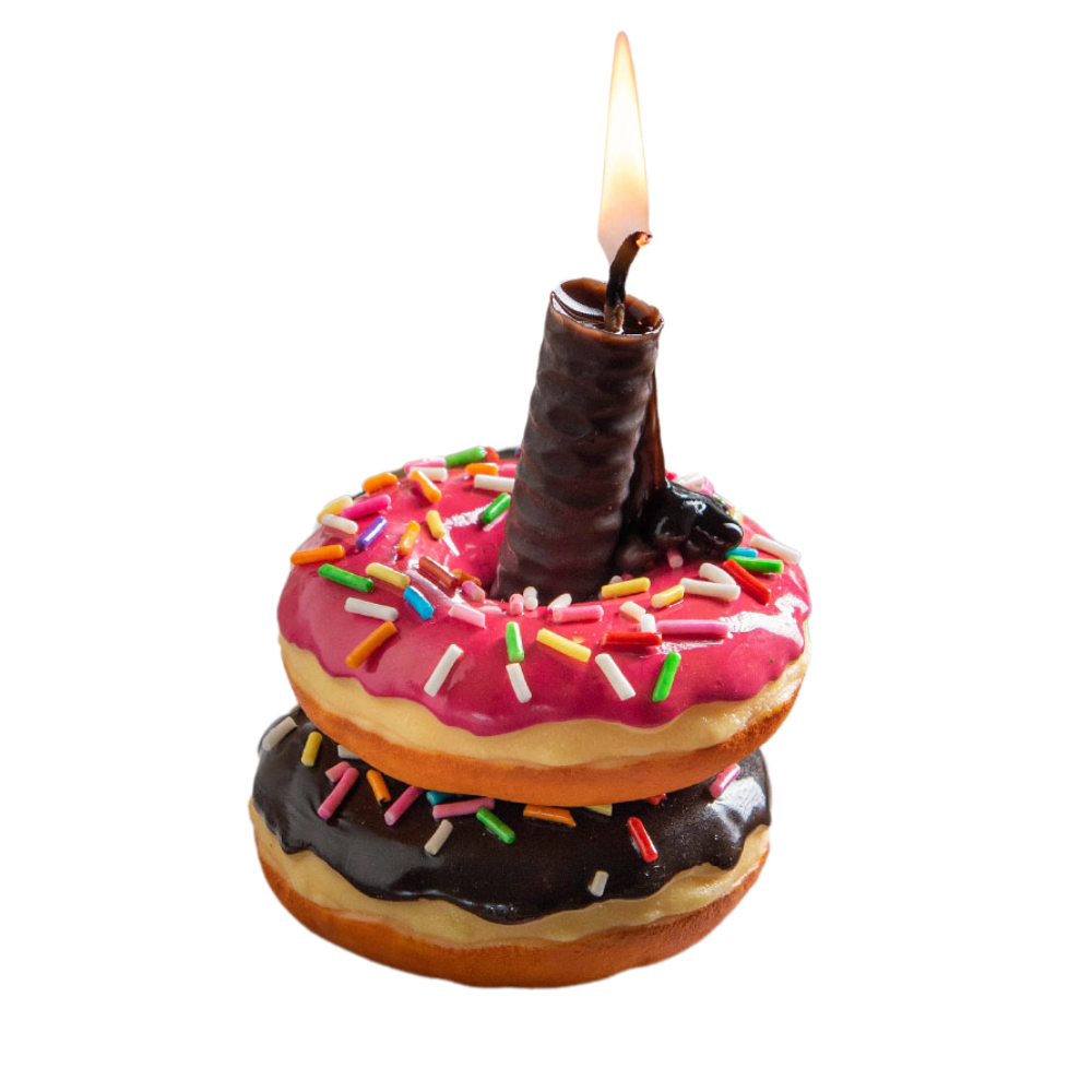 Stack of donuts with pink icing and sprinkles, topped with a lit candle, on a white background.