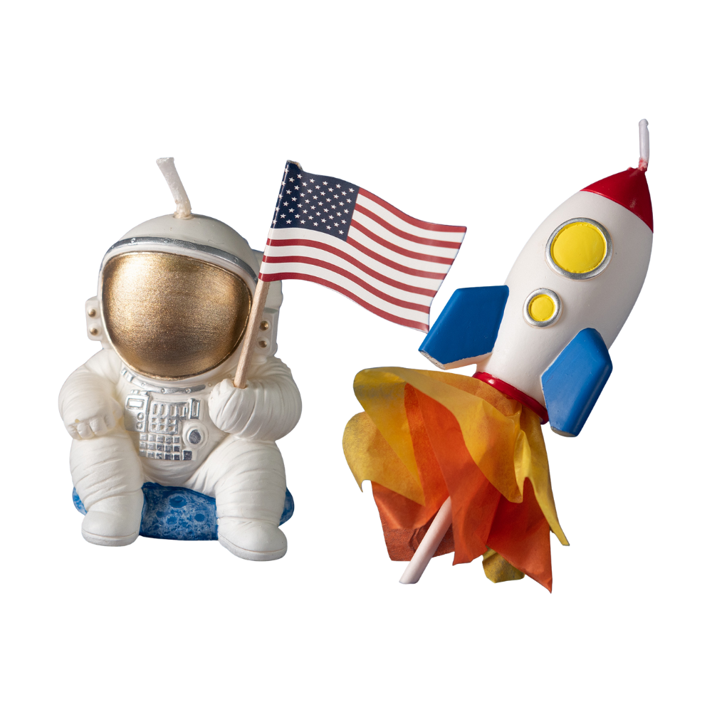 Toy astronaut holding an American flag and a toy rocket on a white background