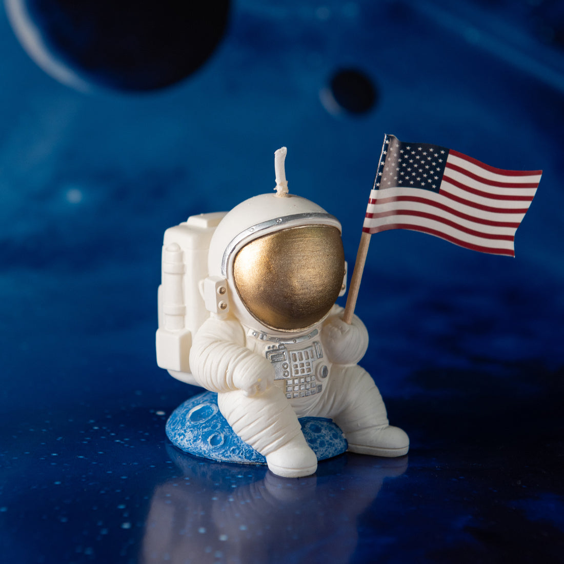 Side view of Southlake Gifts Astronaut Landing Candle seated on a blue planet, a handcrafted soy wax astronaut candle inspired by space exploration, a unique gift for science and space lovers.