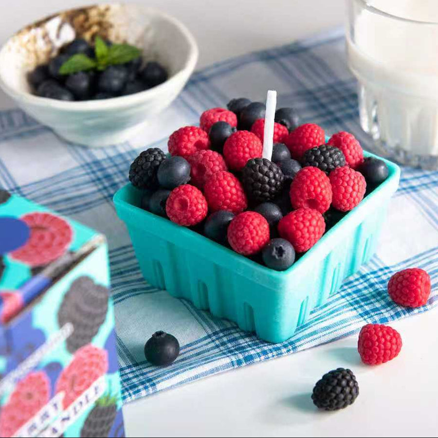 Southlake Gifts Berry Basket Candle displayed on a checkered cloth beside fresh blueberries and milk, featuring handmade raspberry, blueberry, and blackberry wax melts in a teal wax fruit basket — an artisan décor piece and perfect gift for berry lovers.