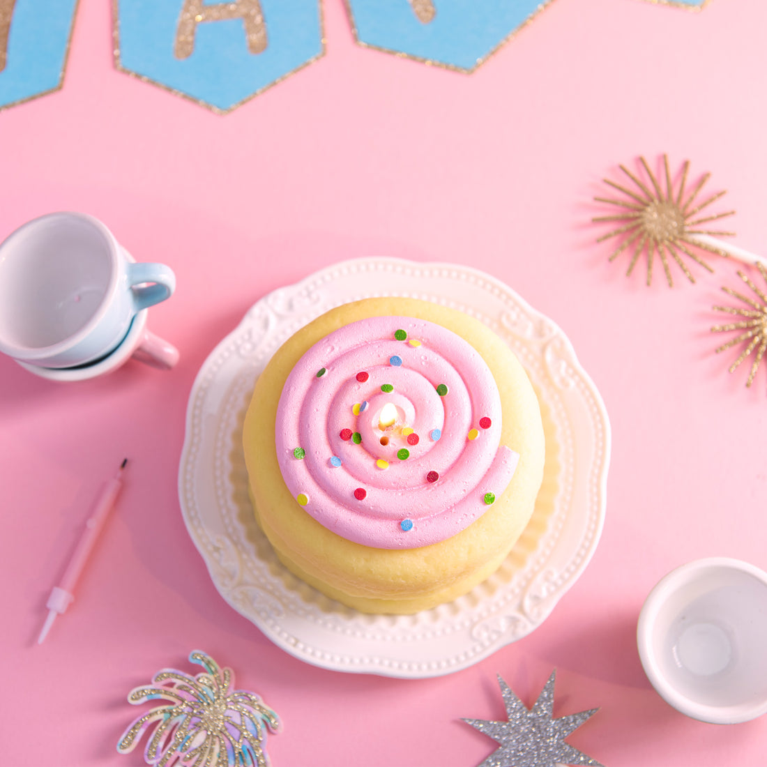 Top view of Southlake Gifts cake cookie candle with pink frosting swirl and colorful sprinkles on a pastel party setup, a handmade vanilla scented dessert candle styled for cute room décor, aesthetic birthday table styling, and a playful gift for girls, teens, and celebration lovers