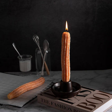 Southlake Gifts Churros Candle Set featuring two realistic churro-shaped candles, one lit and standing in the handmade holder while the other rests beside it. Cozy food-inspired holiday gift candle for home décor and dessert lovers.