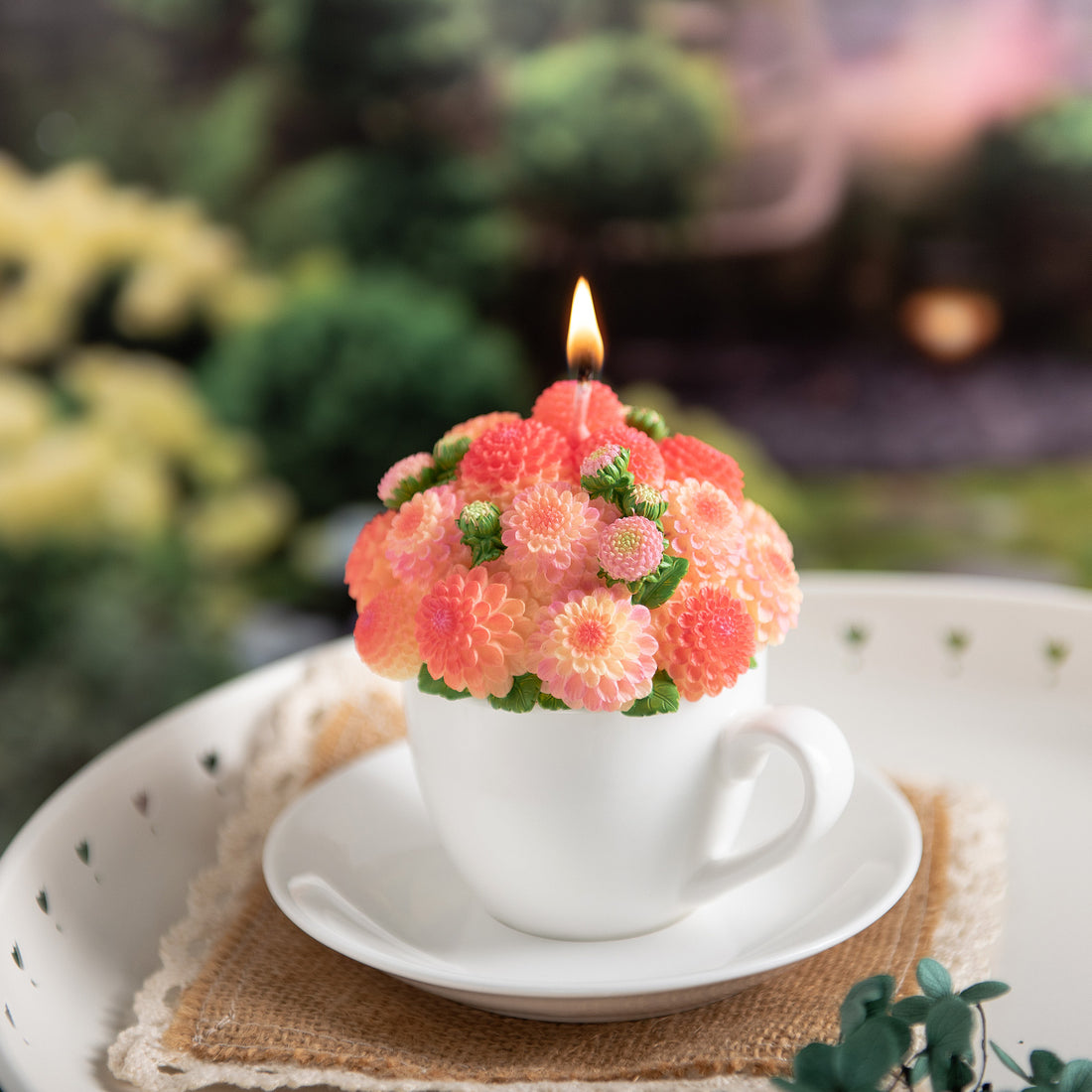 Southlake Gifts Orange Dahlia Teacup Candle lit up with hand-painted wax blossoms, handmade floral candle centerpiece in white cup and saucer