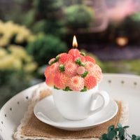 Southlake Gifts Orange Dahlia Teacup Candle lit up with hand-painted wax blossoms, handmade floral candle centerpiece in white cup and saucer