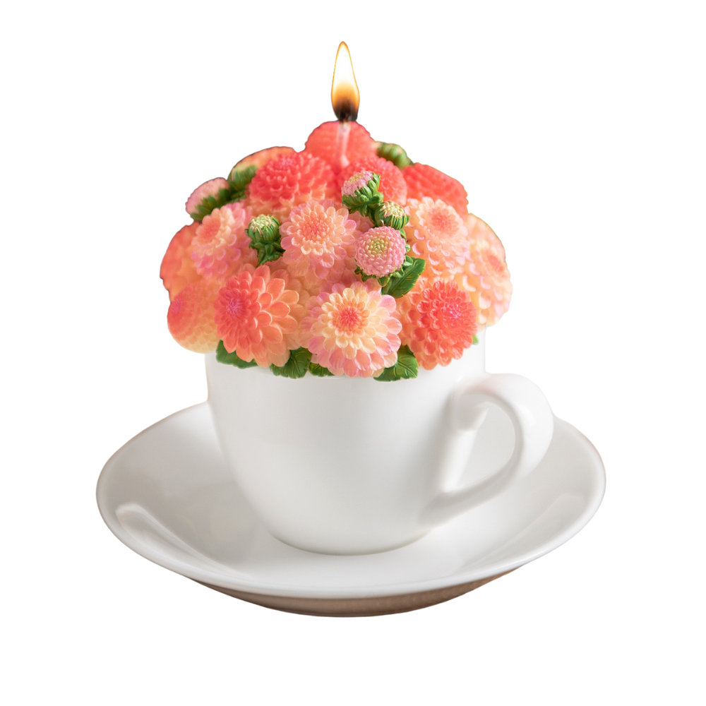 Southlake Gifts handmade Dahlia Flower Teacup Candle is lit up, orange wax bouquet in porcelain-style cup and saucer, floral scented décor gift in white background.