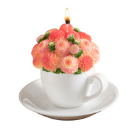 Southlake Gifts handmade Dahlia Flower Teacup Candle is lit up, orange wax bouquet in porcelain-style cup and saucer, floral scented décor gift in white background.