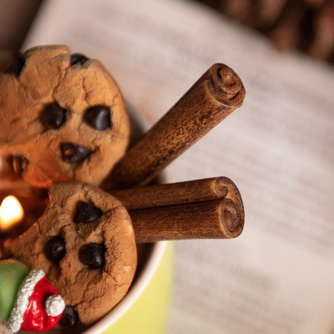 Close up look at the Cinnamon sticks candle wax melt and Chocolate Chip cookies wax melts sitting inside the  holiday cocoa candle mug — handcrafted by Southlake Gifts for realistic food candle. 