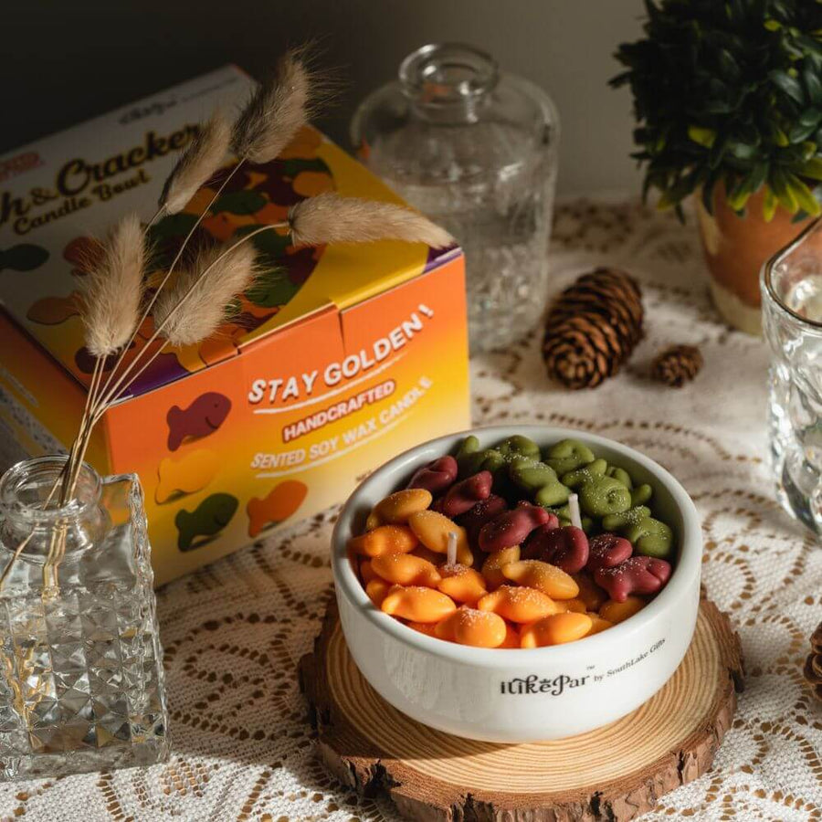 Southlake Gifts Fish & Crackers Scented Candle Bowl beside its gift box and dried plants, handmade realistic food candle décor, a charming artisan gift for home fragrance lovers.