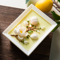 Handcrafted framed magnolia candle by Southlake Gifts shown lying flat while lit, highlighting sculpted magnolia blossoms and branches inside a picture-frame candle design, a botanical scented candle that makes a beautiful artisan gift for home styling lovers.
