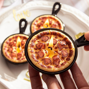 Southlake Gifts Heart Pepperoni Mini Pizza Candle Trio held in hand, featuring three mini pizza candles with heart-shaped pepperoni in black reusable skillets. A realistic food candle set perfect for gifting, weddings, and pizza lovers.