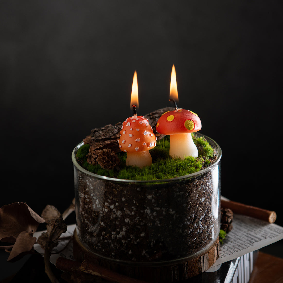 Southlake Gifts Mini Mushroom Candle Set glowing inside a woodland terrarium scene with moss, bark, and forest textures, featuring two tiny mushroom candles with spotted caps, a whimsical cottagecore mushroom decor candle perfect for woodland home decor, miniature table styling, and unique gifts for mushroom lovers.
