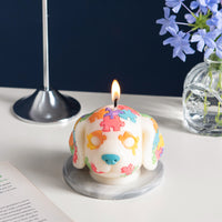 Front angle of the Southlake Gifts Puzzle Pup Candle lit – novelty dog candle with vibrant puzzle design, handmade soy wax décor piece