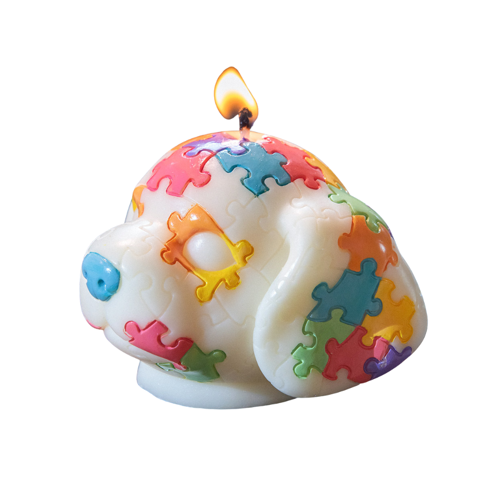 Southlake Gifts Puppy Puzzle Cute Animal Candle lit up. A miniature shape like a dog with hand-painted colorful puzzle pieces on a white background