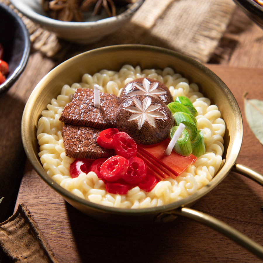 Southlake Gifts Ramen Noodle Candle, handmade novelty food candle in golden ramen pot with wax beef slices, scallions, mushrooms, and chili peppers.