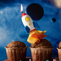 Southlake Gifts Rocket Launch Candle lit atop a cupcake with flame detail, a handmade space-themed cake topper candle designed for birthday celebrations and imaginative cake decoration.