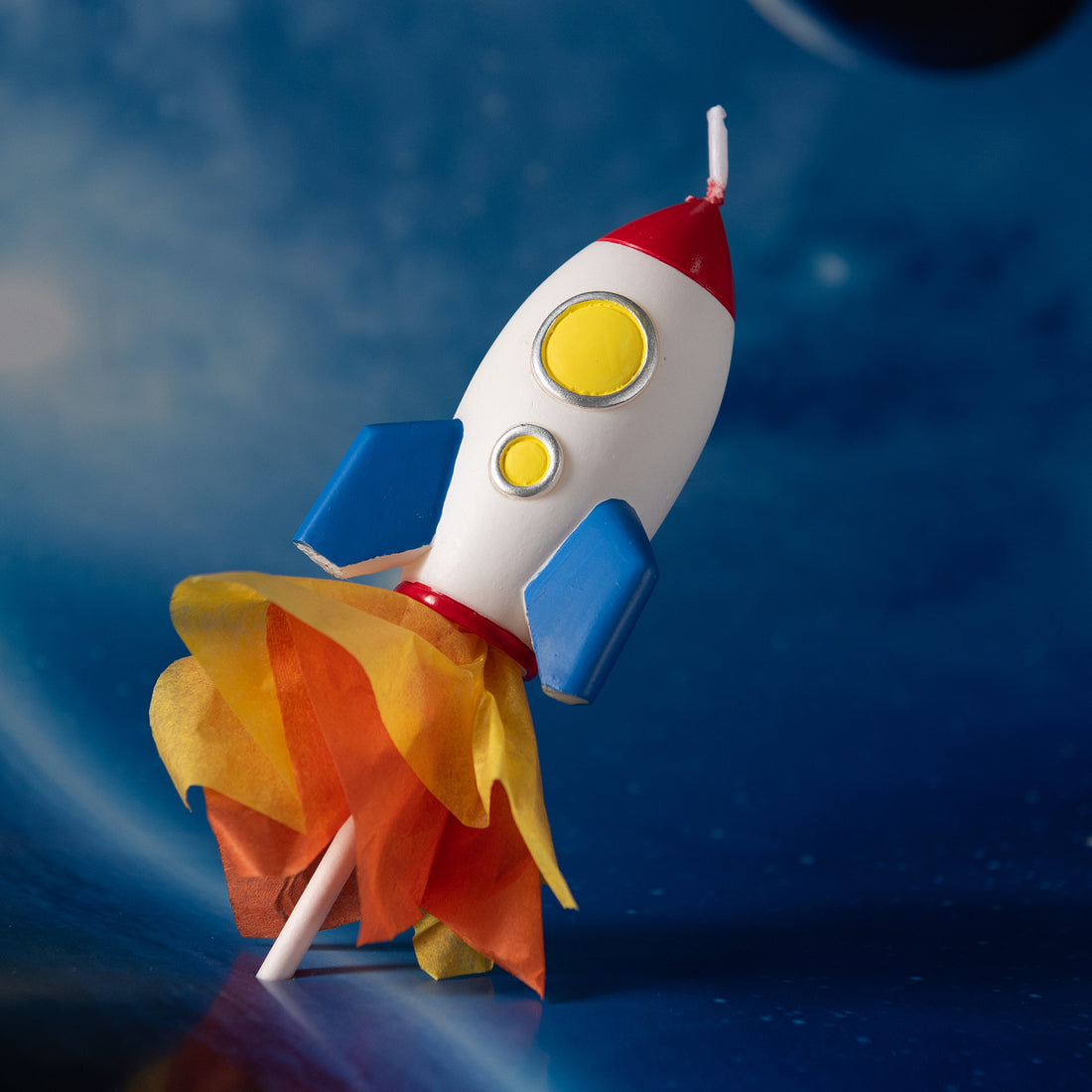 Close-up of Southlake Gifts rocket candle with DIY paper flame detail, handmade soy wax space rocket candle used as party décor, a fun artisan gift for kids and space themed events.