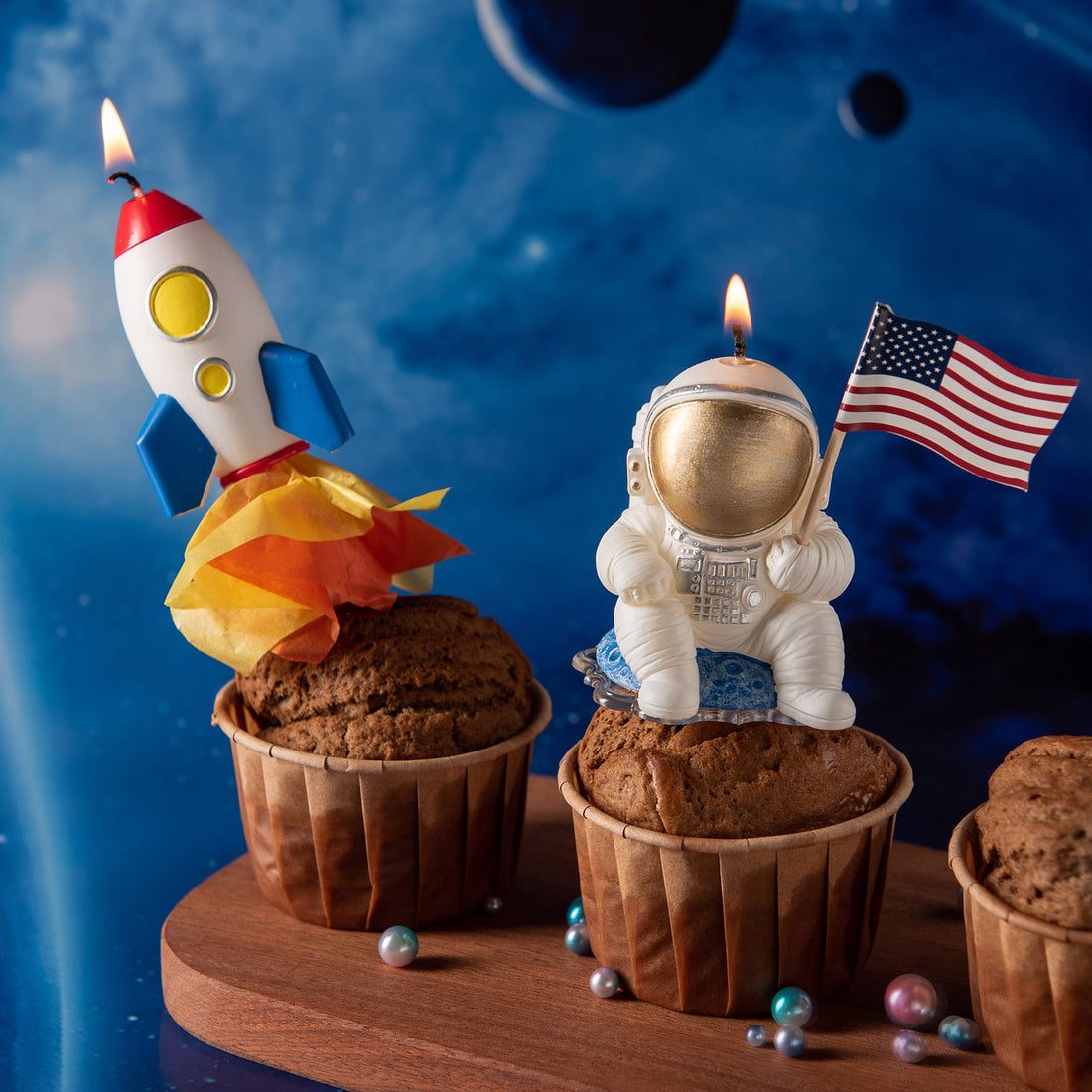Southlake Gifts rocket candle and astronaut candle displayed on cupcakes as space themed cake toppers, handmade soy wax candles for birthdays, a creative gift for space fans and party décor.