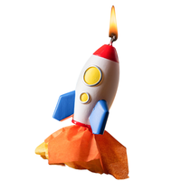 Southlake Gifts rocket launch candle lit against a white background, handmade soy wax space rocket with flame detail, a unique decorative candle and gift for space themed celebrations.