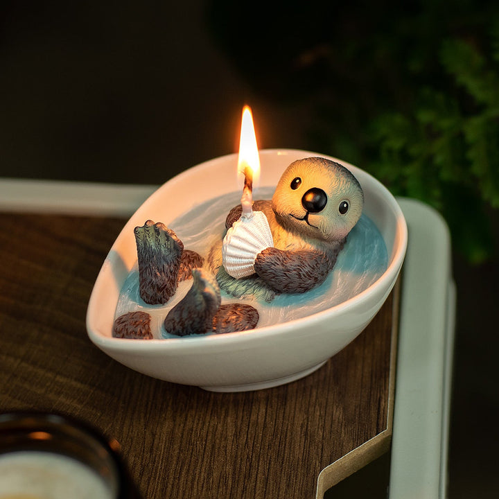 Southlake Gifts Sea Otter Cute Animal Candles is lit on and putting on the table as cute animal candle top decor and unique holiday gifts. 