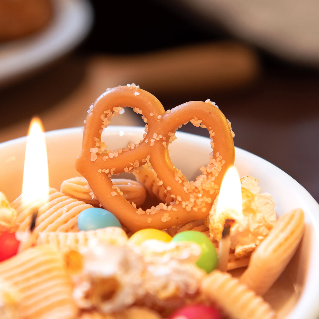 Close-up of Southlake Gifts handmade snack candle featuring a realistic pretzel-shaped wax detail, showcasing artisan craftsmanship and texture, a novelty décor candle that makes a charming gift for any occasion.