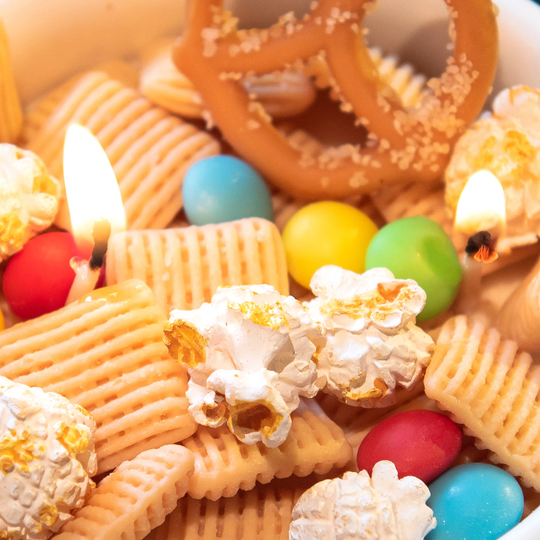 Macro detail of Southlake Gifts realistic snack-shaped wax elements including popcorn and crackers inside the Snacks Candle Bowl, emphasizing handcrafted artistry, an artisan handmade candle perfect as a playful yet elevated gift.