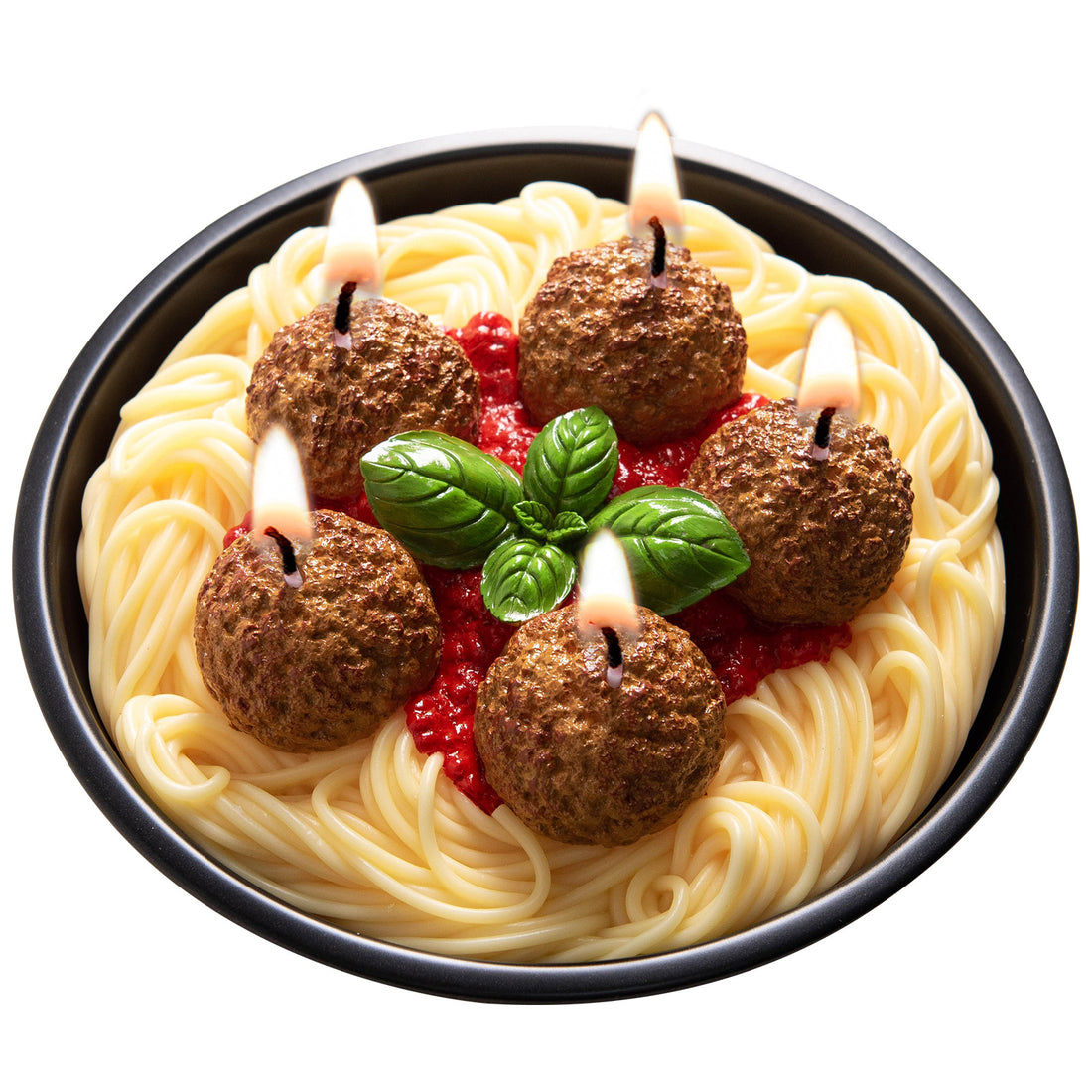 Southlake Gifts Spaghetti with meatballs candle, and shaped like basil leaves, plus tomato sauce sitting on a pen and lit on a black reusable pan in a white background