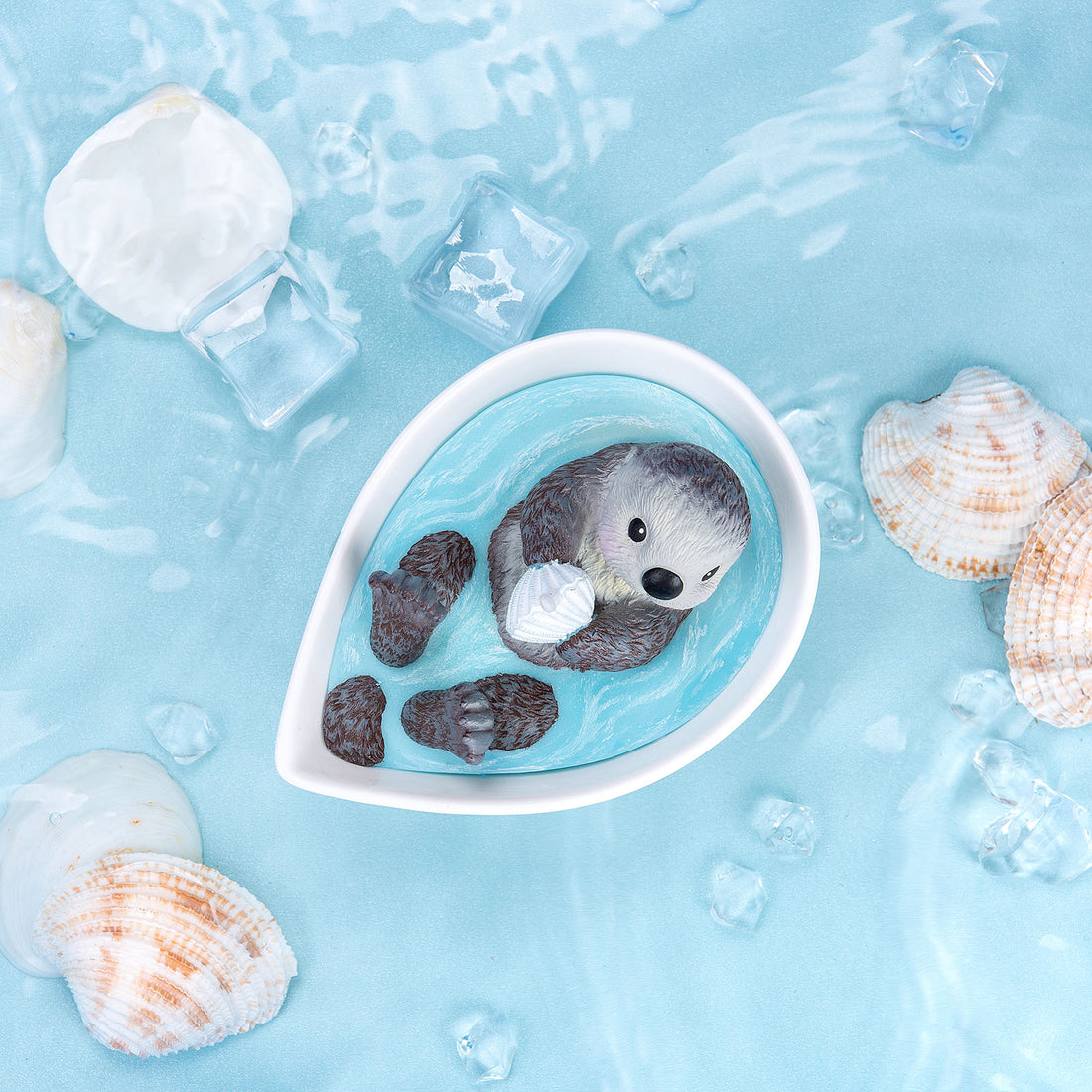 The Baby Sea Otter chilling on the bath while holding a shell.