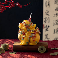 Southlake Gifts Pixiu Fortune Candle displayed on a red textile with traditional Chinese coins, a handcrafted soy wax Pixiu symbolizing wealth and prosperity, perfect as a Lunar New Year gift and meaningful home décor.